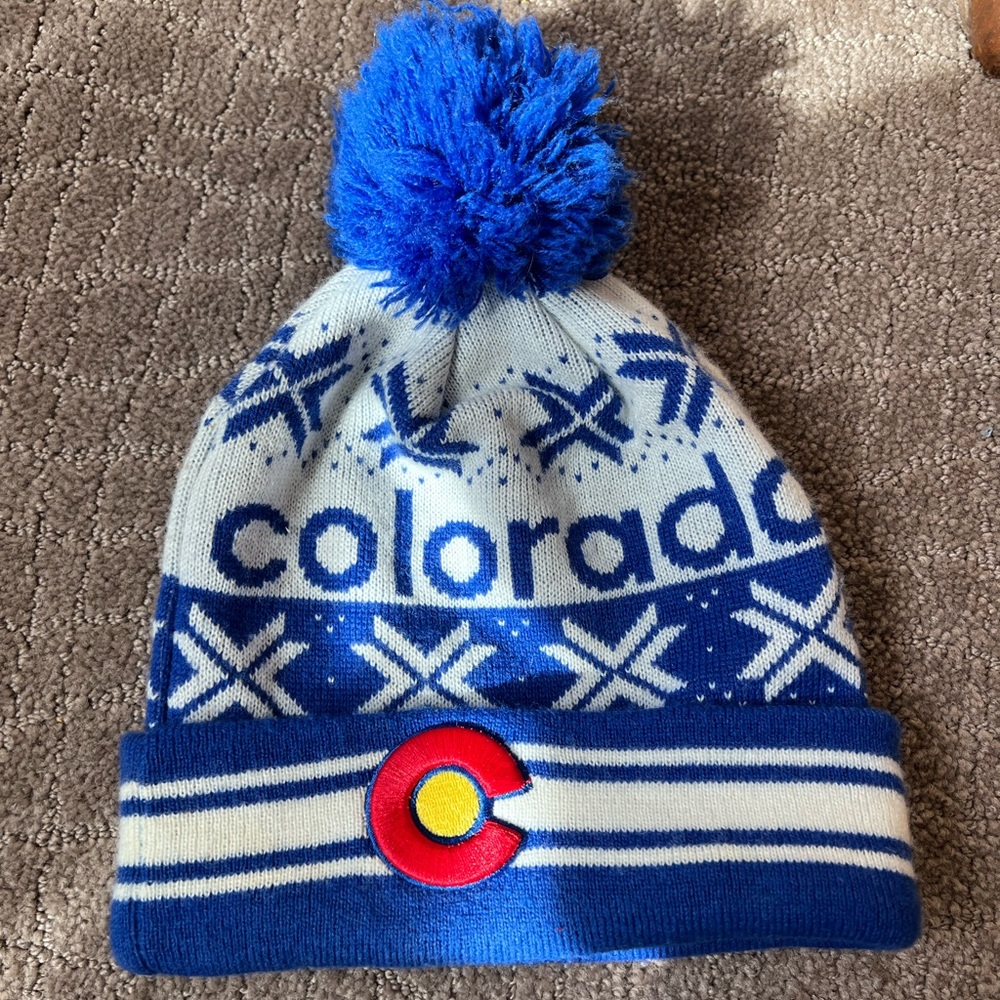 Colorado knitted beanie with a Pom Pom and hand stitched Colorado flag emblem